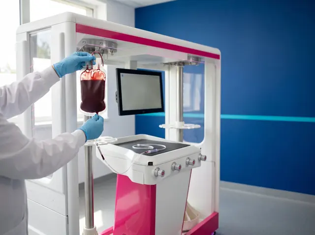 Manos con guantes colgando una bolsa de sangre en el sistema de filtración de leucocitos LMB FILTRAmatic